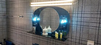 a mirror on a wall with lights in a bathroom at Cosy apartment in Chalandri in Athens