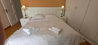 a white bed with two white towels on it at Cosy apartment in Chalandri in Athens