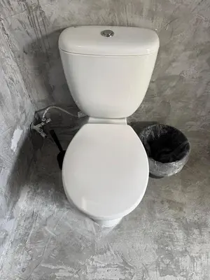 a white toilet in a bathroom with a trash can at Factory in Athens