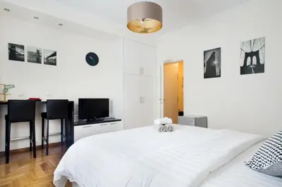 a white bedroom with a white bed and a tv at Syntagma Rita apartment 2 in Athens