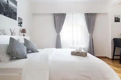 a bedroom with a large white bed with curtains at Syntagma Rita apartment 2 in Athens