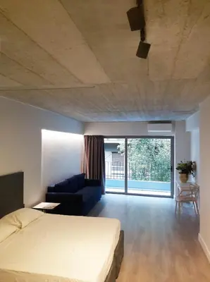 a bedroom with a bed and a couch and a large window at The Link Athens in Athens