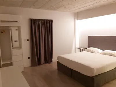 a bedroom with a large bed and a window at The Link Athens in Athens