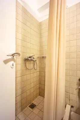 a bathroom with a shower with a shower curtain at Acropolis Elegant Maisonette by LODGESPOT in Athens