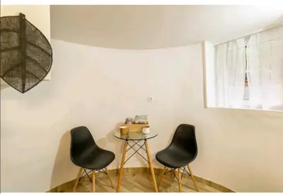 two chairs and a table in a room with a window at Acropolis Elegant Maisonette by LODGESPOT in Athens