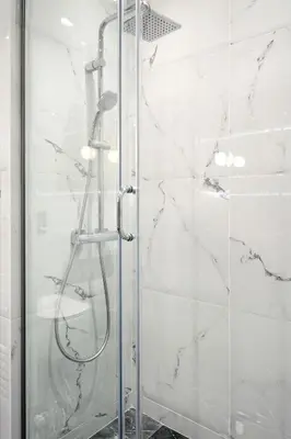 a shower with a glass door in a bathroom at Urban Melodies Apartment in Athens