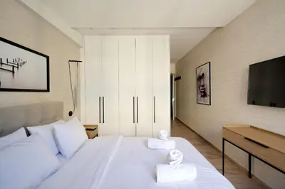 a bedroom with a white bed with two towels at Urban Melodies Apartment in Athens