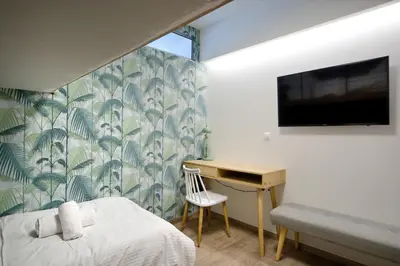 a bedroom with a desk and a tv and a bed at Urban Melodies Apartment in Athens