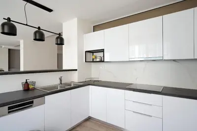 a white kitchen with white cabinets and a sink at Urban Melodies Apartment in Athens