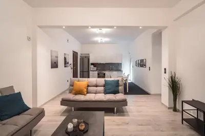 a living room with a couch and a kitchen at Urban Serenity Gem in Kallithea neighbourhood! in Athens