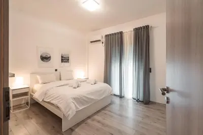 a white bedroom with a white bed and a window at Urban Serenity Gem in Kallithea neighbourhood! in Athens