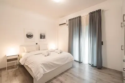 a white bedroom with a bed and a window at Urban Serenity Gem in Kallithea neighbourhood! in Athens