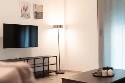 a living room with a flat screen tv and a table at Urban Serenity Gem in Kallithea neighbourhood! in Athens