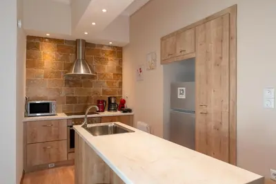 a kitchen with a sink and a counter top at Contemporary apartment made of wood and stone. in Athens