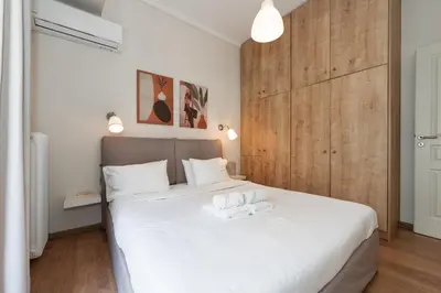 a bedroom with a bed with two towels on it at Contemporary apartment made of wood and stone. in Athens