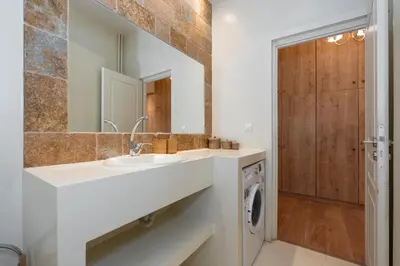 a bathroom with a sink and a washing machine at Contemporary apartment made of wood and stone. in Athens