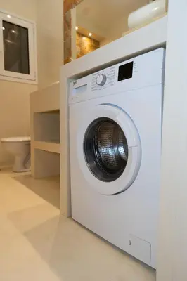 a white washing machine sitting in a bathroom at Contemporary apartment made of wood and stone. in Athens