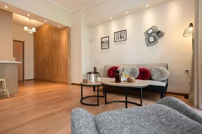 a living room with a couch and a table at Contemporary apartment made of wood and stone. in Athens