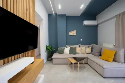 a living room with a couch and a flat screen tv at Trojan Affair Residence in Athens