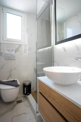 a white bathroom with a sink and a toilet at Trojan Affair Residence in Athens