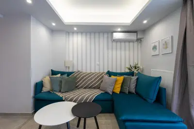 a living room with a blue couch and a table at Trojan Affair Residence in Athens
