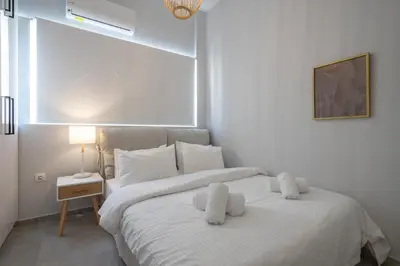 a bedroom with a white bed with two stuffed animals on it at Trojan Affair Residence in Athens