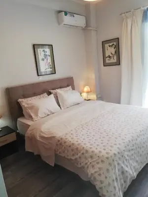 a bedroom with a bed with white sheets and a window at Gazi view apartments #1 in Athens