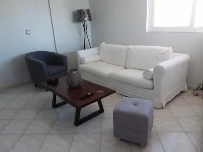 a living room with a white couch and a table at Gazi view apartments #1 in Athens