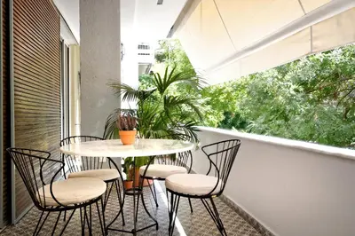 a balcony with a table and chairs and a window at The Fancy Philosopher Apartment in Athens