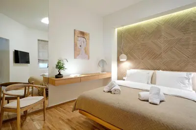 a bedroom with a bed and a chair and a desk at The Fancy Philosopher Apartment in Athens