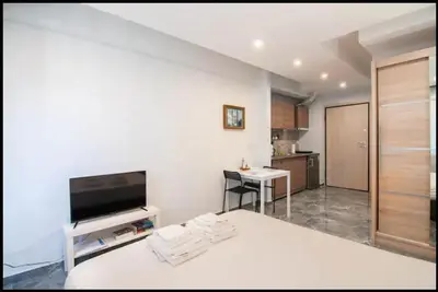 a large white room with a bed and a kitchen at COZY Studio, Athens city center in Athens