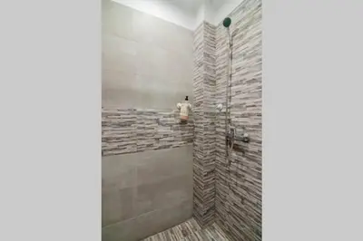 a man standing in a shower in a bathroom at COZY Studio, Athens city center in Athens