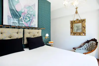a bedroom with a large bed and a chair at Eclectic 4-Bed, 4-Bath Apt in Central Athens - AK1 in Athens