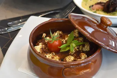 a bowl of food with a tomato in it on a plate at Athenian Montaza Hotel in Athens