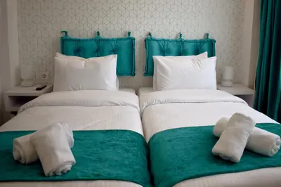 two beds in a room with towels on them at Athenian Montaza Hotel in Athens