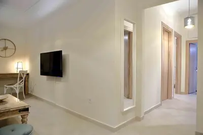 a living room with a tv on a white wall at Best House, Anakreontos, Perivolaki, Nikaia, P... in Piraeus