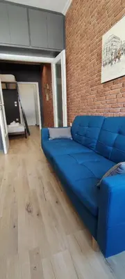a blue couch in a room with a brick wall at AS Athens Central Cozy Apartment 2 in Athens