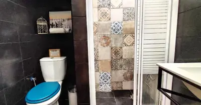 a bathroom with a toilet and a tile wall at AS Athens Central Cozy Apartment 2 in Athens