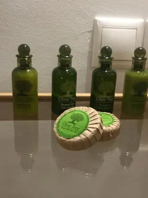 three bottles of green liquid and a cookie on a table at White Tundra Studio in Athens