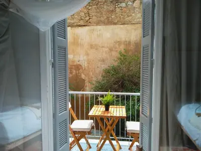 a balcony with a table and chairs and a bed at White Tundra Studio in Athens