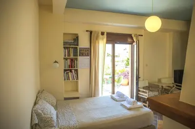 a bedroom with a bed and a book shelf and a window at Sunny Top Floor Studio - Excellent Athens view in Athens