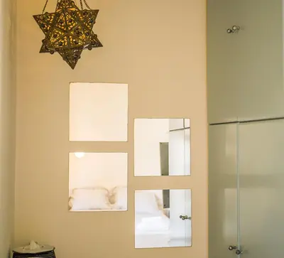 a bathroom with two mirrors and a chandelier at Sunny Top Floor Studio - Excellent Athens view in Athens
