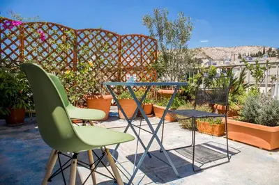 a table and chairs on a patio with plants at Sunny Top Floor Studio - Excellent Athens view in Athens