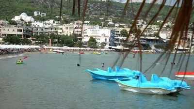 two boats sitting in the water near a beach at Artemis Rooms in Agia Marina Aegina