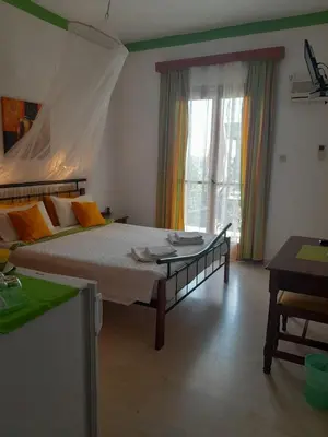 a bedroom with a large bed with a canopy at Artemis Rooms in Agia Marina Aegina