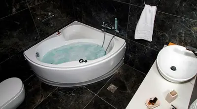 a bathroom with a tub with blue water in it at Hotel Thissio in Athens