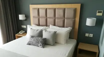 a bedroom with a white bed with pillows and a phone at Hotel Thissio in Athens