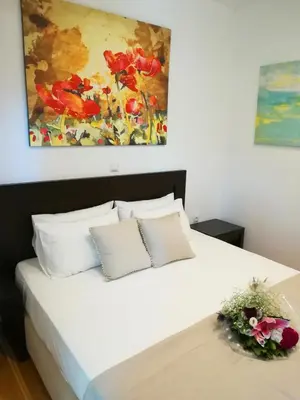 a bedroom with a white bed with a painting on the wall at Hotel Thissio in Athens