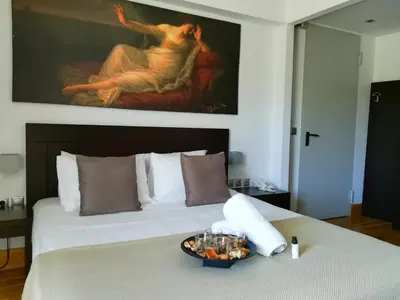 a bedroom with a bed with a painting on the wall at Hotel Thissio in Athens