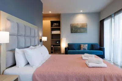 a bedroom with a large bed and a blue couch at Hotel Thissio in Athens